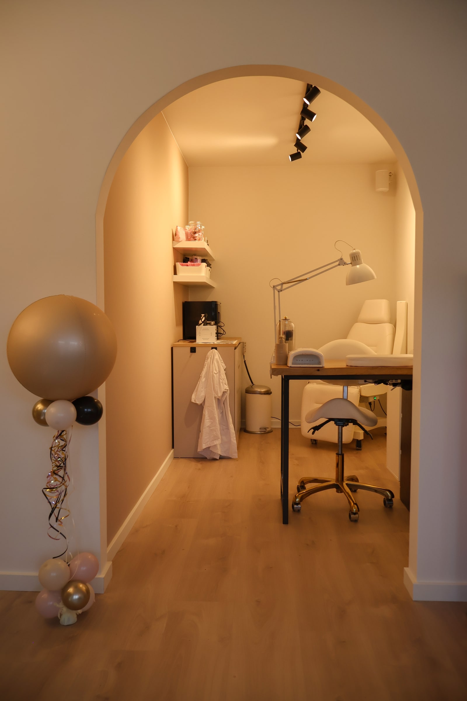 De boog naar de nagelkamer, met ballonnen op de openingsdag